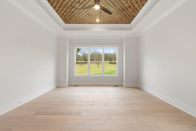 empty room featuring ornamental molding, wood ceiling, light hardwood / wood-style floors, and a tray ceiling