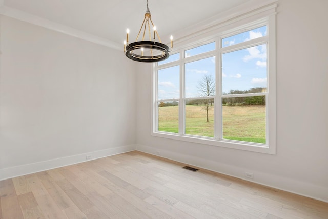 unfurnished room featuring crown molding, a chandelier, and light hardwood / wood-style floors