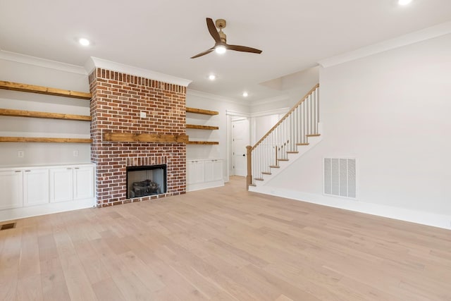 unfurnished living room featuring crown molding, a fireplace, and light hardwood / wood-style floors