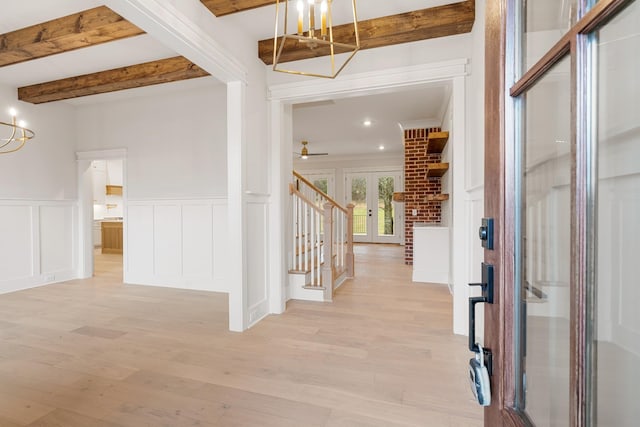 entrance foyer with french doors, beam ceiling, ceiling fan with notable chandelier, and light hardwood / wood-style floors