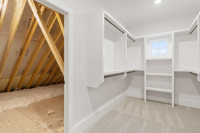 walk in closet featuring light carpet