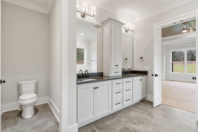 bathroom featuring vanity, hardwood / wood-style flooring, ornamental molding, and toilet