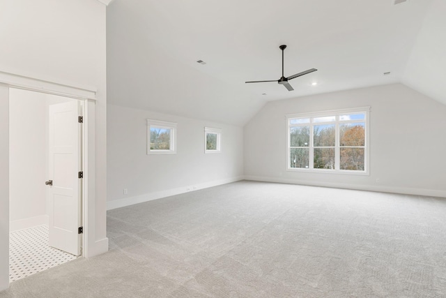 additional living space featuring light carpet, lofted ceiling, and ceiling fan