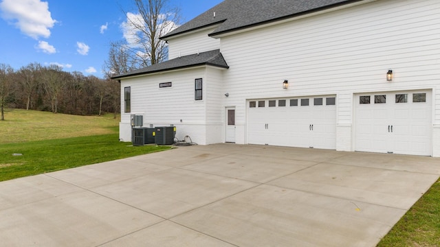 view of home's exterior featuring a garage, a yard, and central AC