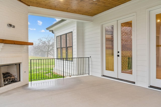 view of patio / terrace with an outdoor brick fireplace and french doors