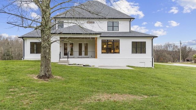 back of house featuring a porch, a yard, and a patio area