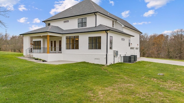 back of house with central AC unit, a yard, a patio area, and french doors