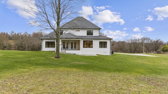 back of house with covered porch and a lawn