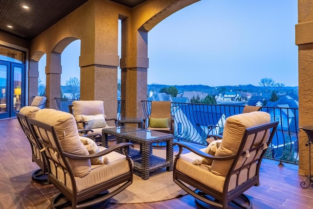 patio terrace at dusk featuring a mountain view and a balcony