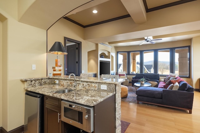 kitchen with sink, ceiling fan, light hardwood / wood-style floors, crown molding, and light stone countertops