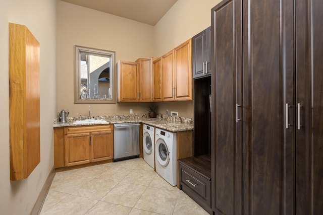 laundry room featuring sink, light tile patterned floors, washing machine and dryer, and cabinets