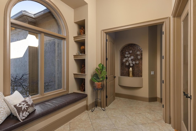 hallway featuring light tile patterned floors and built in features