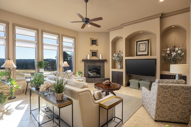 living room featuring ceiling fan, a fireplace, and light tile patterned floors