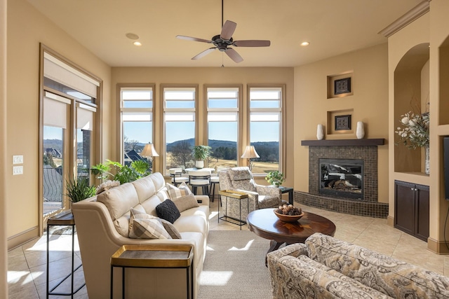 living room featuring a mountain view, light tile patterned floors, and ceiling fan