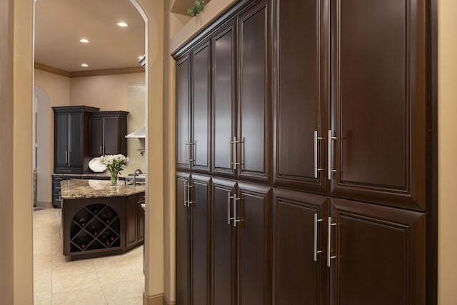 corridor with light tile patterned floors and crown molding