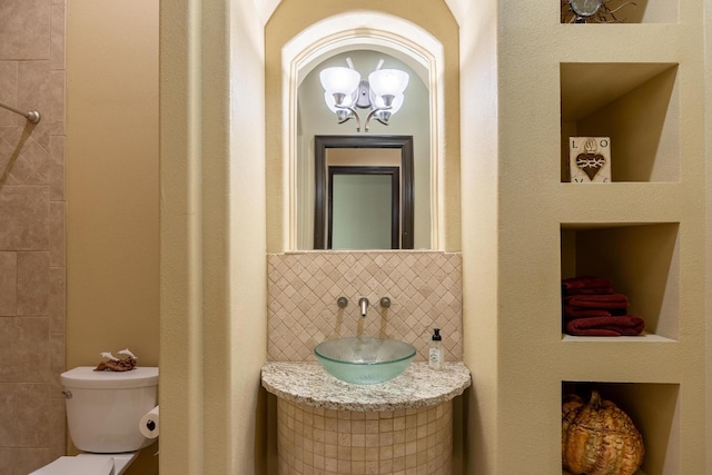 bathroom with tasteful backsplash, vanity, and toilet