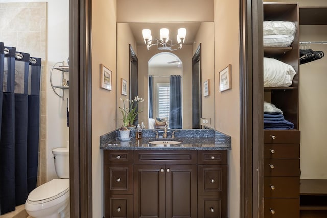 bathroom with vanity, a chandelier, and toilet