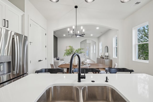 kitchen featuring decorative light fixtures, white cabinetry, sink, a chandelier, and stainless steel fridge with ice dispenser