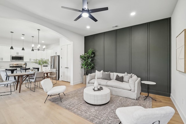 living room with ceiling fan and light wood-type flooring