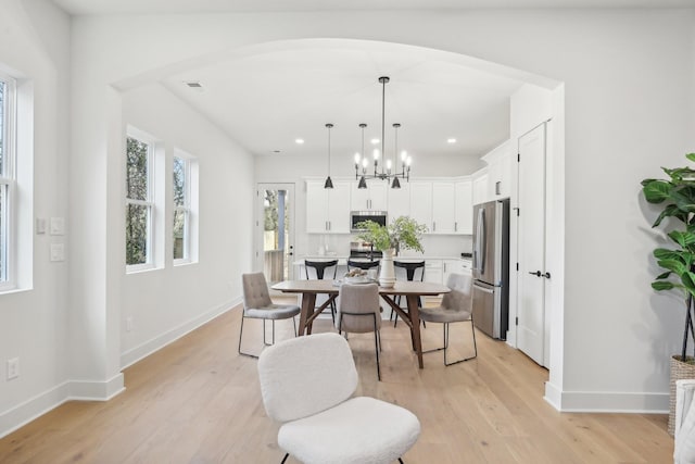 dining area featuring a notable chandelier and light wood-type flooring