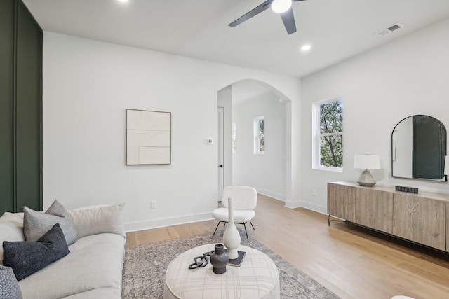 living room with ceiling fan and light hardwood / wood-style flooring