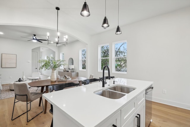 kitchen with decorative light fixtures, sink, white cabinets, a kitchen island with sink, and stainless steel dishwasher