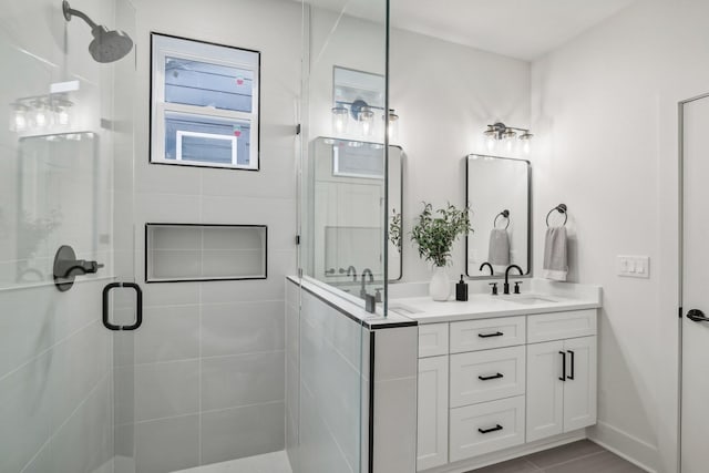 bathroom with vanity and a shower with door