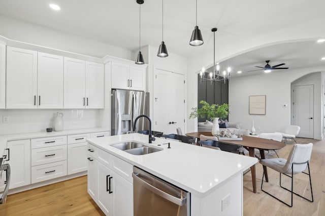 kitchen with a kitchen island with sink, decorative light fixtures, white cabinets, and appliances with stainless steel finishes