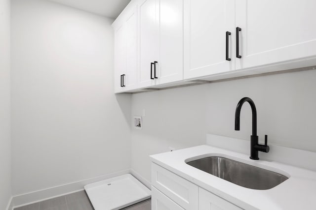 laundry area with hookup for a washing machine, sink, and cabinets