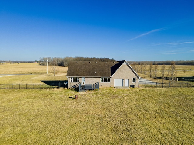 exterior space featuring a garage, a rural view, a deck, and a lawn