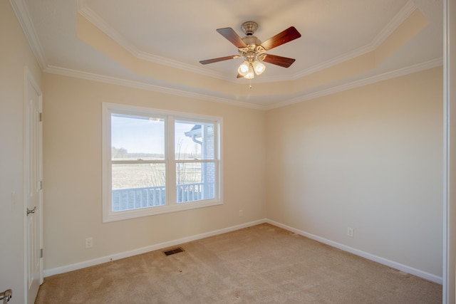 carpeted spare room featuring a raised ceiling, crown molding, and ceiling fan