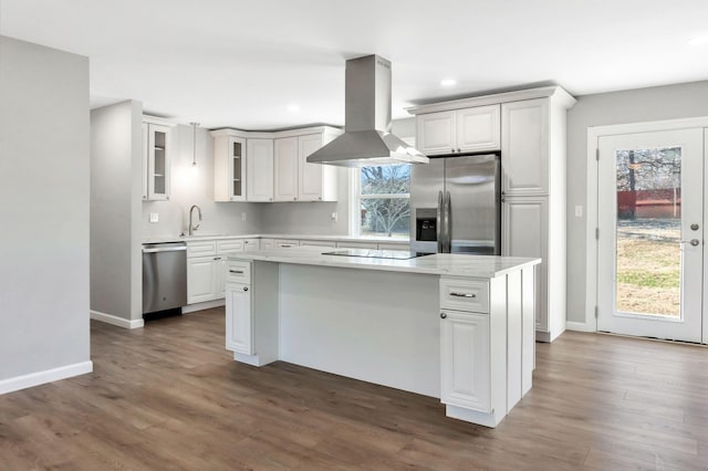 kitchen with sink, white cabinetry, stainless steel appliances, island range hood, and a kitchen island