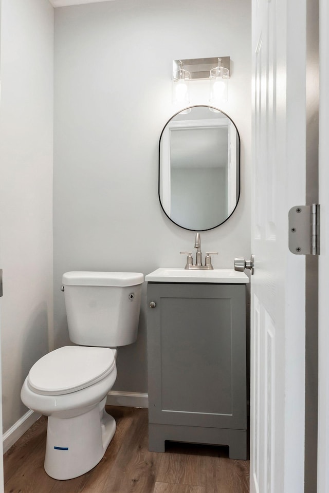 bathroom with hardwood / wood-style flooring, vanity, and toilet