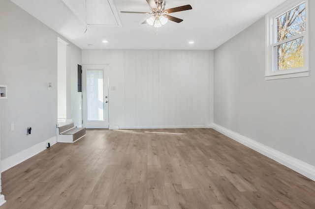 unfurnished room with ceiling fan, electric panel, and light hardwood / wood-style floors