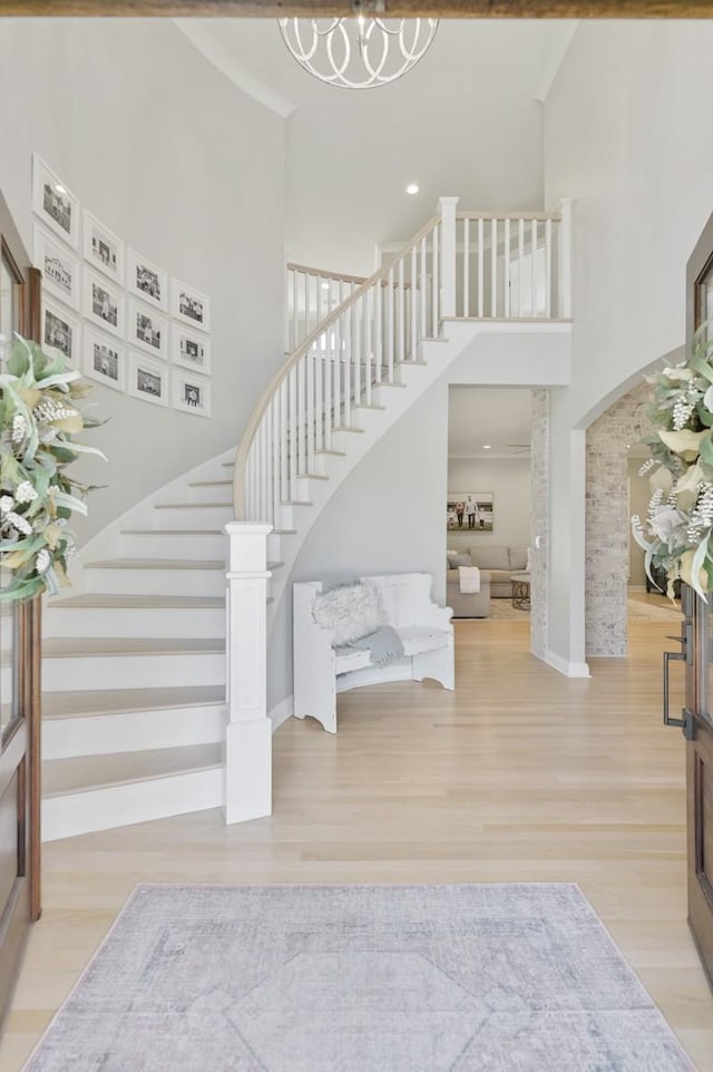 staircase with hardwood / wood-style floors and a high ceiling