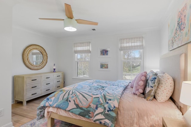 bedroom with multiple windows, crown molding, ceiling fan, and light hardwood / wood-style flooring