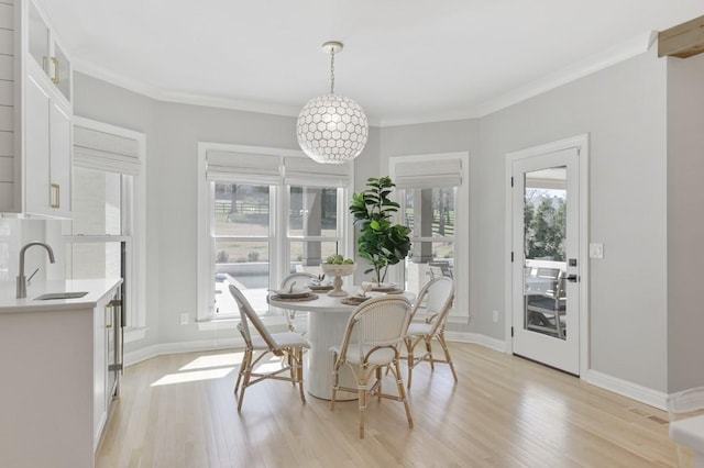 dining space with a healthy amount of sunlight, sink, and light wood-type flooring