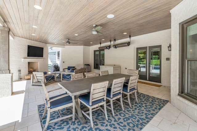 view of patio with an outdoor living space with a fireplace and ceiling fan