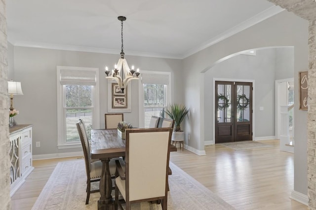 dining room with crown molding, plenty of natural light, a chandelier, and light hardwood / wood-style flooring