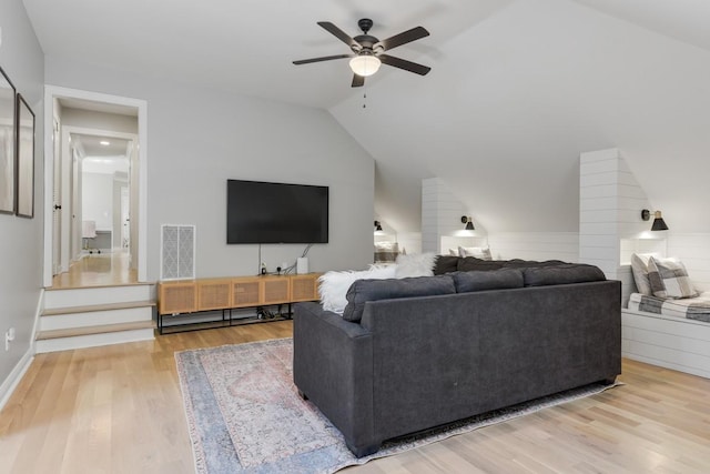 living room featuring wood-type flooring, vaulted ceiling, and ceiling fan