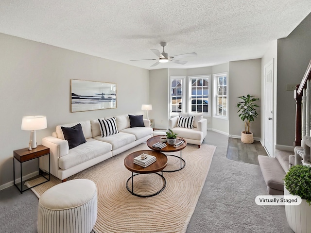 living room featuring ceiling fan and a textured ceiling