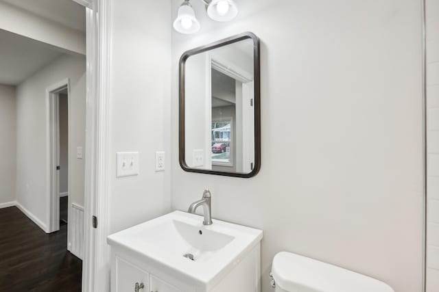 bathroom featuring vanity, toilet, and hardwood / wood-style floors