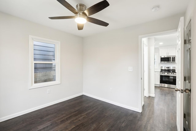 empty room with dark hardwood / wood-style floors and ceiling fan