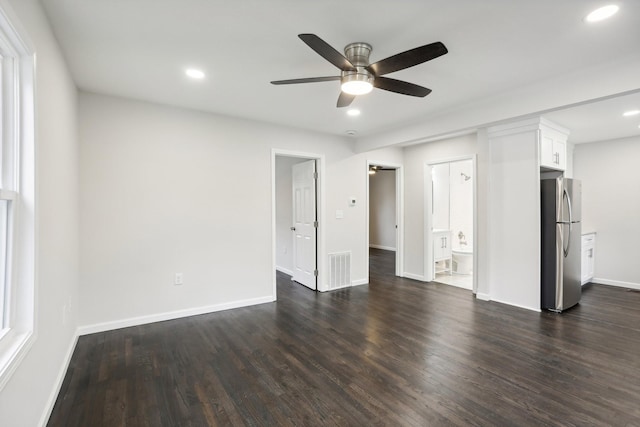 unfurnished living room featuring dark wood-type flooring and ceiling fan