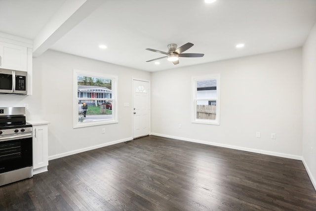 kitchen with appliances with stainless steel finishes, dark hardwood / wood-style floors, white cabinets, and ceiling fan