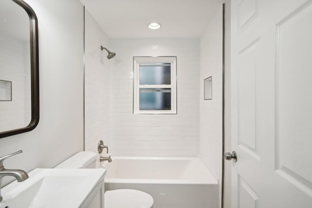 full bathroom featuring tiled shower / bath, vanity, and toilet