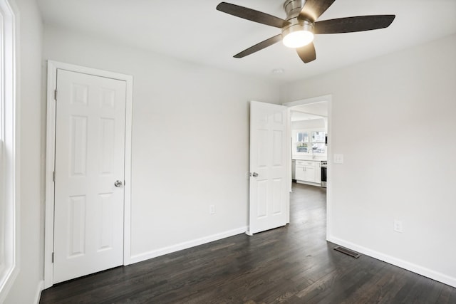 empty room with ceiling fan and dark hardwood / wood-style floors