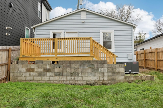 rear view of property featuring cooling unit and a deck