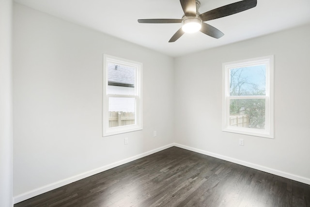 empty room with ceiling fan and dark hardwood / wood-style flooring