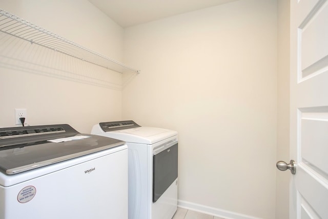 laundry room with washer and dryer and light tile patterned flooring